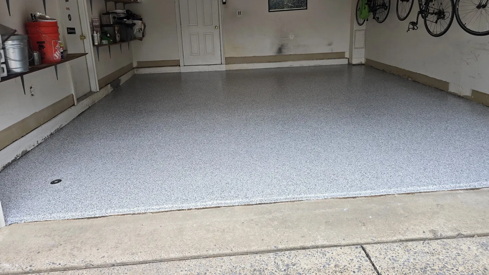 Finished gray and white polyaspartic flake floor filling a clean two-car residential garage