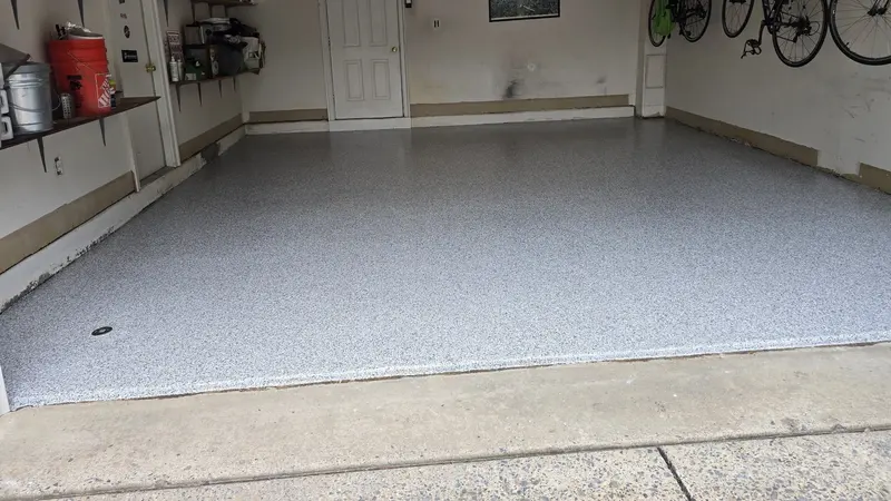 Finished gray and white polyaspartic flake floor filling a clean two-car residential garage